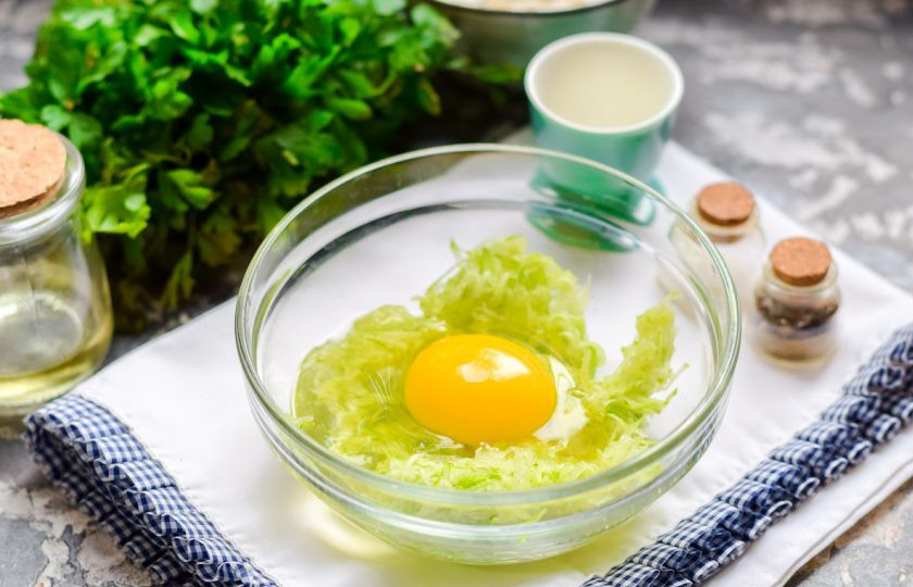 1. Этап. Кабачковые оладьи без масла: Добавьте к кабачкам куриное яйцо.