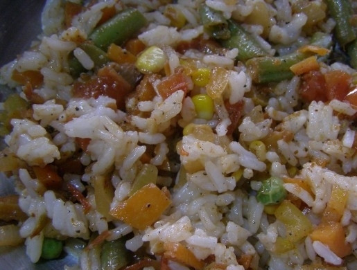 1. Этап. Кальмары, фаршированные рисом и овощами: 7. Теперь к овощам переложите рис, при необходимости можете добавить немного воды. Тушите все вместе минут пять на медленном огне.