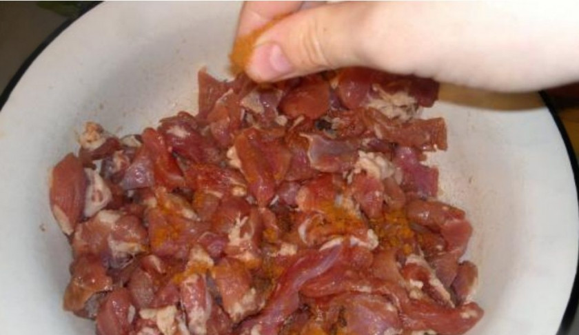 1. Этап. Картошка, тушеная в утятнице: 1. Нарежьте свинину небольшими кубиками. Посолите по вкусу. Добавьте черного и красного перца.