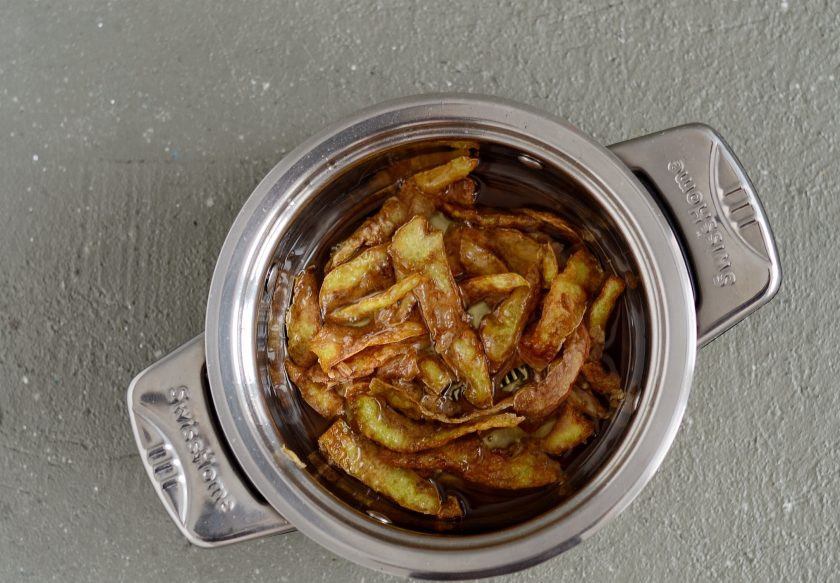 1. Этап. Чипсы из картофельных очисток: На среднем огне нагрейте растительное масло. Опустите туда картофельные очистки, жарьте их до золотистого цвета. На это уйдет примерно 3-5 минут.