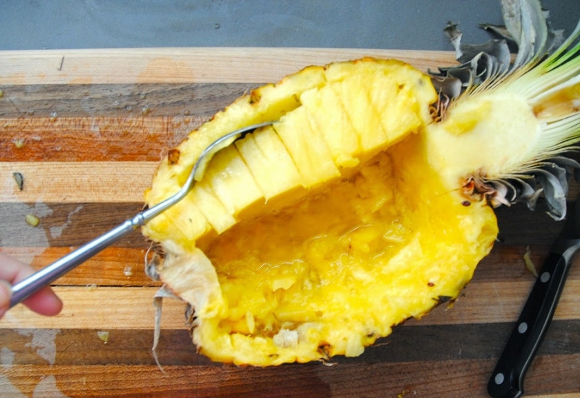 1. Этап. Салат из курицы с ананасом: 2. Мякоть ананаса в двух половинках нарежьте кубиками и затем при помощи ложки выберите.
