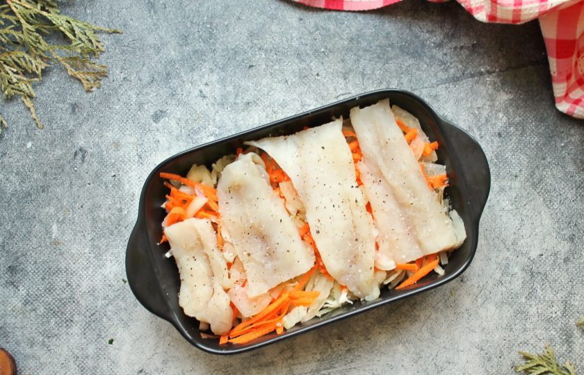 1. Этап. Треска с капустой: Из трески сделайте филе, удалите все кости и кожу. Разрежьте филе порционно, посолите, поперчите и выложите на овощи. Закройте треску оставшимися морковью с луком.