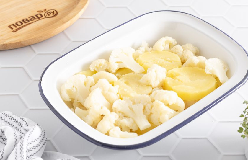 1. Этап. Цветная капуста с картошкой в духовке: Выложите в форму для запекания картофель с цветной капустой.