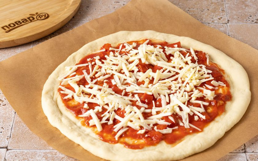 1. Этап. Овощная пицца: Тесто растяните до толщины 5-6 мм., придайте ему форму круга и сформируйте бортики. Смажьте центр томатным соусом и посыпьте тертым сыром.