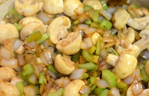 1. Этап. Рецепт вкусного мясного пирога: На сковороду, где жарилось мясо, добавьте лук и чеснок и обжарьте до мягкости. Добавьте грибы и сельдерей и протомите еще 5 минут.