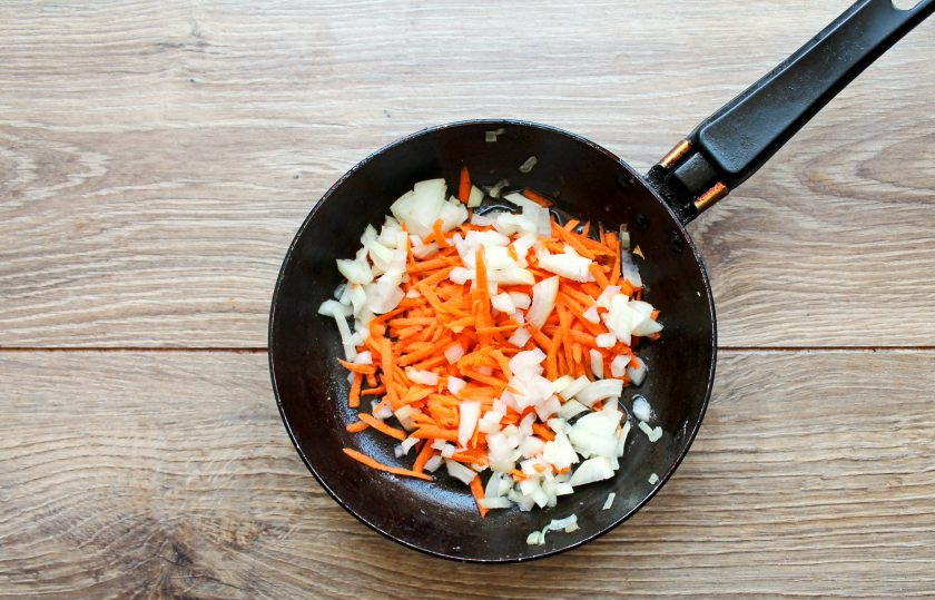 1. Этап. Сырный суп с куриными желудками: В сковороду налейте растительное масло и разогрейте на среднем огне. Выложите в сковороду мелко нарезанный репчатый лук и натертую на средней терке морковь. Обжаривайте все в течение 7 минут, перемешивая.