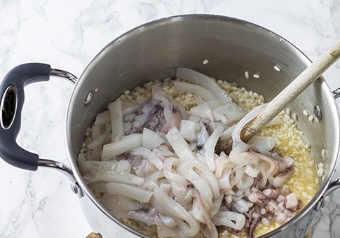 1. Этап. Рис с морепродуктами: Добавляем нарезанные кальмары. Перемешиваем и продолжаем готовить.