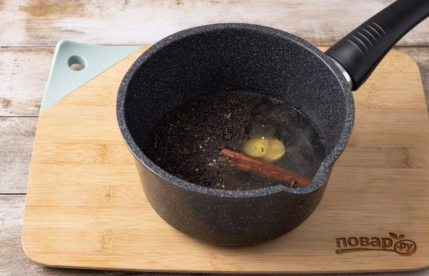 1. Этап. Глинтвейн Зимний: Вскипятите воду в кастрюле. Добавьте все пряности, порезанный кружочками корень имбиря и черный листовой чай.