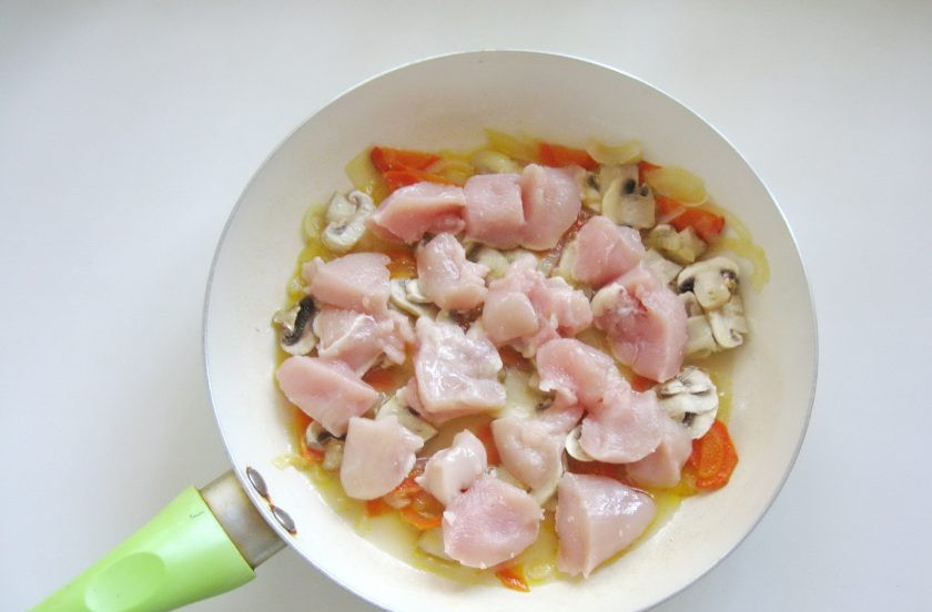 1. Этап. Куриное филе с шампиньонами в сметане: Куриное филе помойте, нарежьте небольшими кусочками. Выложите в сковороду с овощами и грибами.