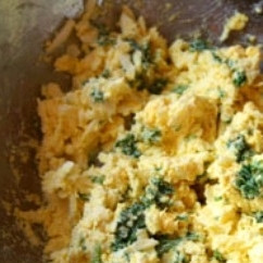 1. Этап. Яйца, фаршированные сыром и чесноком: Посыпаем начинку мелко рубленной петрушкой и перемешиваем.