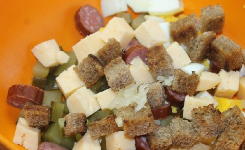 1. Этап. Салат с охотничьими колбасками: Последним ингредиентом добавьте сухарики, обжаренные до золотистой корочки.