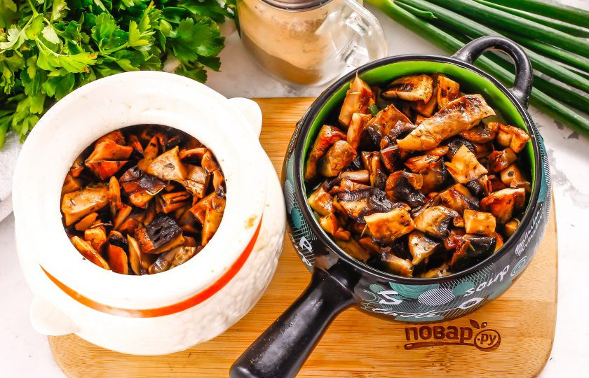 1. Этап. Пельмени по-царски: Выложите на слой сметаны поджаренные грибы. Разогрейте духовку до 200 градусов. Так как пельмени в горшочках горячие, то и сами горшочки будут горячими и не треснут от разницы температур, а блюдо запечется быстрее.