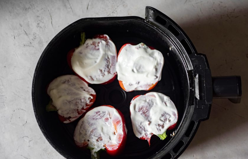 1. Этап. Фаршированные перцы в аэрогриле: Выложите все заполненные половинки перцев на нижнюю решетку чаши аэрогриля, смажьте поверхность каждой половинки перцев одной чайной ложкой сметаны, включите максимальный обдув и запекайте при температуре 200 градусов в течение 25 минут.