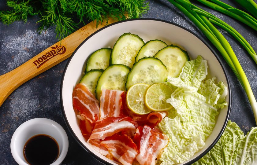 1. Этап. Поке: Промойте свежий огурец и срежьте хвостики с его сторон. Нарежьте ломтиками и выложите на рис. Добавьте туда же полоски копченого бекона или другую мясную продукцию, копченую рыбу или угря. Нарвите руками промытые листья салата или пекинской капусты. Нарежьте лайм или лимон ломтиками и выложите.