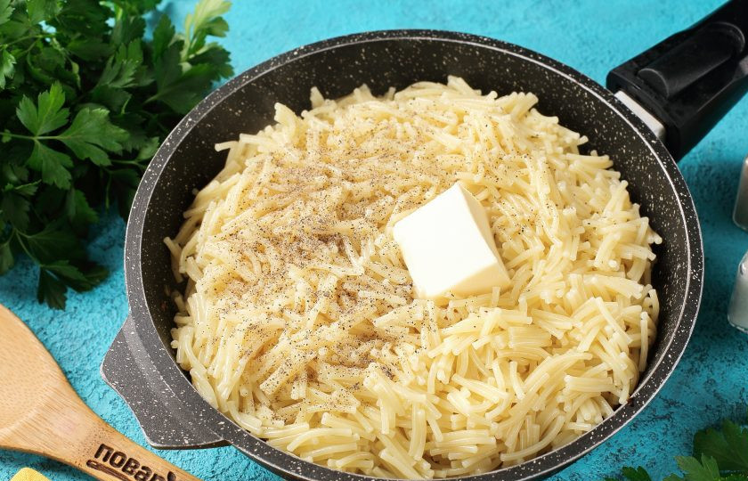 1. Этап. Вермишель с луком: Готовую вермишель откиньте на дуршлаг и отправьте в сковороду. Добавьте кусочек сливочного масла, соль и перец по вкусу и прогрейте пару минут.