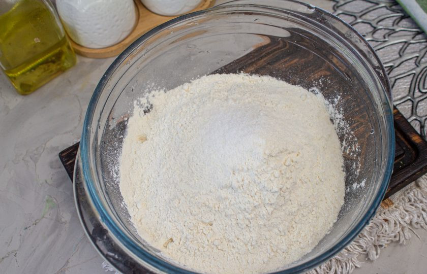 1. Этап. Чуду с черемшой: В миску просейте 300 грамм муки (30 грамм отложила для подпыла), добавьте соль.