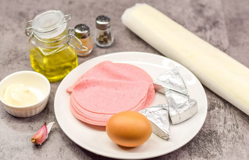 1. Этап. Закуска «Ракушки» из слоеного теста с начинкой: Подготовьте все необходимые ингредиенты. Куриные яйца отварите вкрутую — 12 минут. После яйца остудите и почистите. Духовку разогрейте и установите температуру 180 градусов.