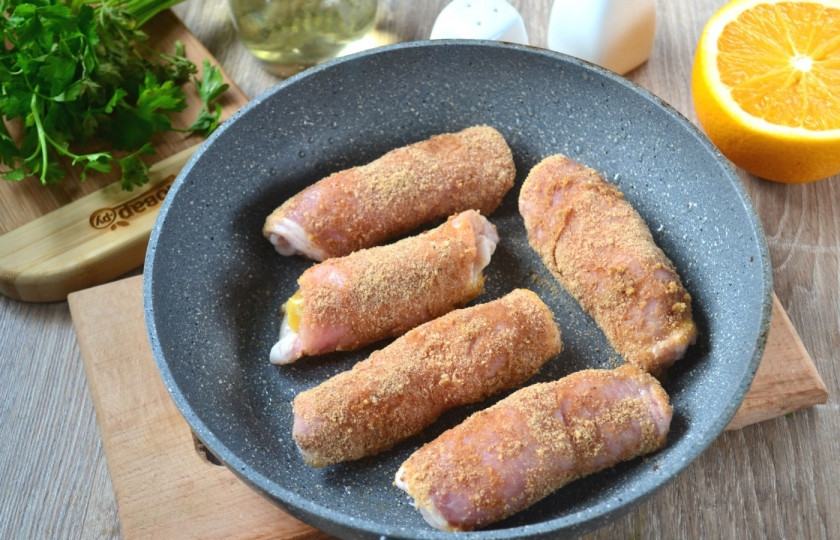 1. Этап. Мясные рулетики с сюрпризом: Взбейте яйцо. Обмакните рулетики сначала в яйцо, а затем обваляйте в панировочных сухарях.