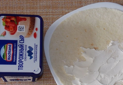 1. Этап. Сладкая тортилья с творожным сыром: Один край смазать творожным сыром, немного отступив от краев.