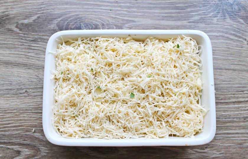 1. Этап. Гратен с беконом: Сыр натрите на мелкой терке и засыпьте верх картофельного слоя.