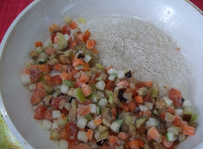 1. Этап. Рис, тушенный с овощами: Хорошо промойте рис. На этом этапе не ленитесь, иначе рис не получится рассыпчатым. Добавьте его на сковороду. Влейте воду.