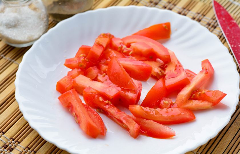 1. Этап. Грузинский салат с колбасой и помидорами: Сочный помидор нарежьте полосками.