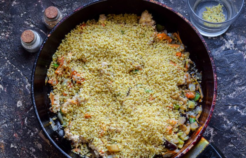 1. Этап. Булгур с фаршем: Добавьте в сковороду булгур, соль и перец по вкусу.