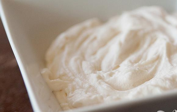 1. Этап. Шоколадные коржики с кремом и клубникой: 6. Приготовить крем. Для этого в миске миксером взбить сливки, сахарную пудру и ванильный экстракт в течение 3-5 минут, пока масса не загустеет.