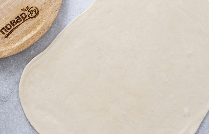 1. Этап. Лепешки на воде с луком: Раскатайте тесто в тонкий прямоугольный пласт. Смажьте растительным маслом.