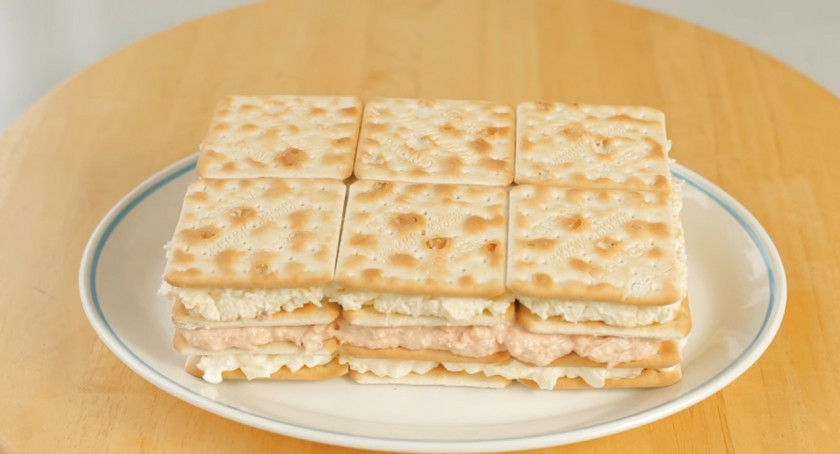 1. Этап. Лучший закусочный торт из крекеров и рыбной консервы: 9. Распределите сырный слой начинки на третьем слое крекеров, выложите сверху последний слой крекеров.