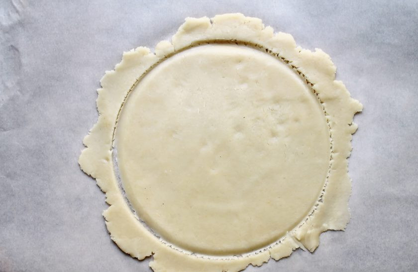 1. Этап. Торт с песочными коржами и безе: Песочное тесто разделите на четыре части. Каждую раскатайте на пергаменте в тонкий круг и при помощи формы диаметром 18 сантиметров обозначьте круг.