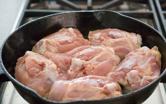 1. Этап. Куриные бедра по-мароккански: Разогрейте духовку до 175 градусов. Нагрейте 1 ст.л. оливкового масла на среднем огне в большой чугунной сковороде, положите кусочки курицы кожей вниз.