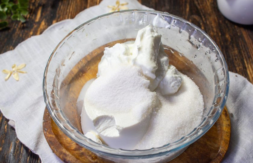 1. Этап. Рулет Рафаэлло: Пока рулет остывает, приготовьте крем. В миску выложите творожный сыр, йогурт, сахар и ванилин. Все тщательно перемешайте.