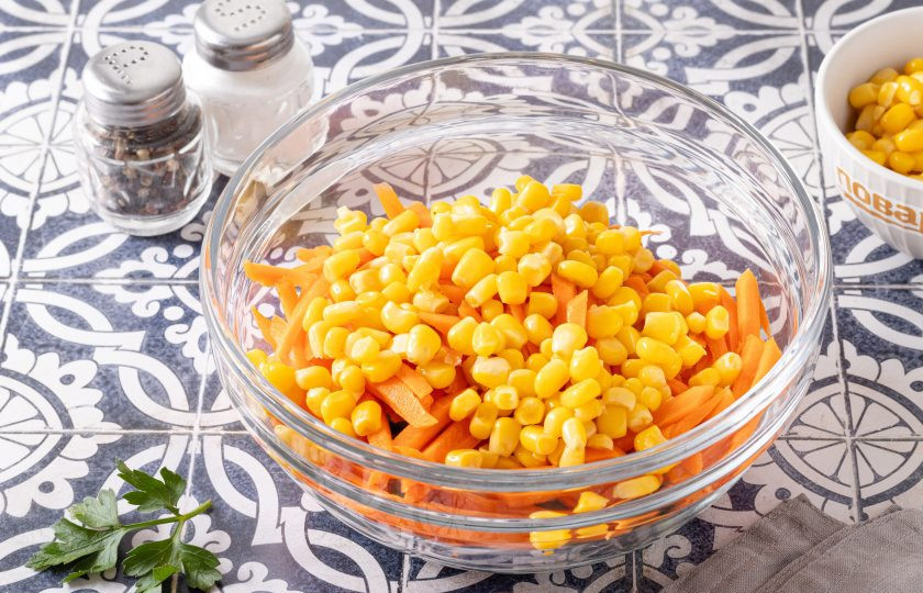 1. Этап. Салат с морковью, огурцом и кукурузой: Слейте жидкость с консервированной кукурузы и переложите в миску.