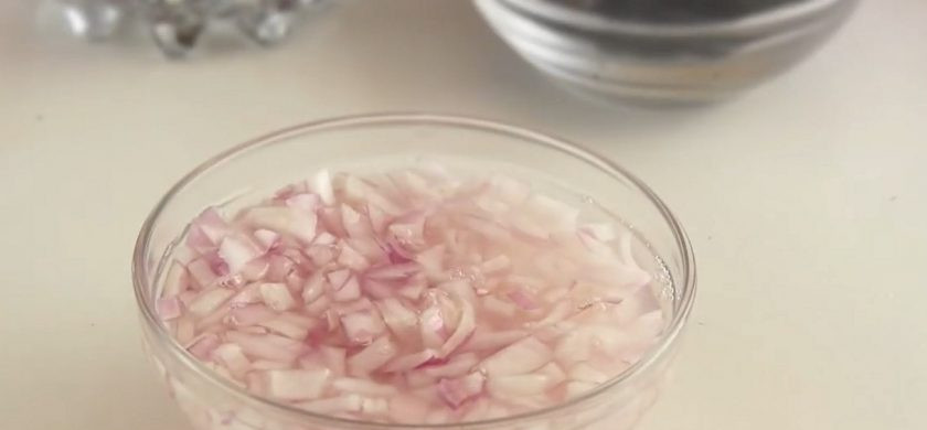 1. Этап. Салат на Новый год Принцесса: 1. Мелко нарежьте лук и замаринуйте его в течение 5-10 минут, залив водой и добавив 1 ст. ложку уксуса. Бортики разъемной формы установите на блюдо.