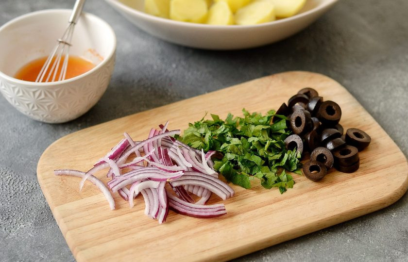 1. Этап. Марокканский картофельный салат: Лук нарежьте тонкими полукольцами, листья петрушки отделите от стебля и порубите. Маслины нарежьте кольцами.