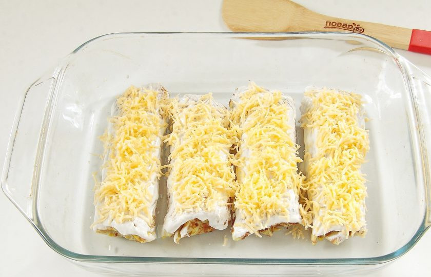 1. Этап. Тыквенные рулетики с печенью: Смажьте верх сметаной и посыпьте тертым сыром.