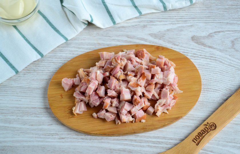 1. Этап. Салат с копченым мясом и огурцом: Из копченого окорочка снимите кожу. Мясо отделите от кости, нарежьте его на мелкие кусочки.