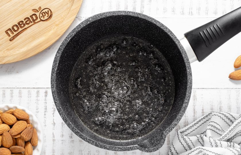 1. Этап. Ореховая халва: В сотейнике соедините воду с сахаром. Доведите до кипения на небольшом огне и проварите пару минут. Влейте растительное масло в горячий сироп, все перемешайте.