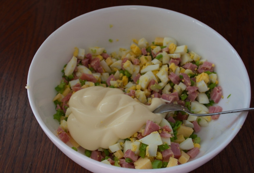 1. Этап. Салат с колбасой и сыром: Заправьте салат майонезом. Добавьте соль и перец по вкусу. Перемешайте.