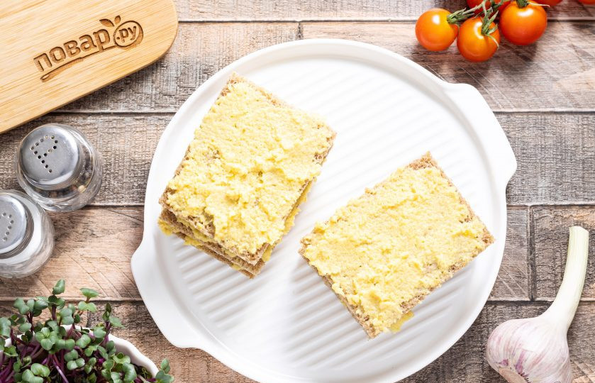 1. Этап. Гренки в аэрогриле: Смажьте ломтики хлеба чесночным пюре, сложите друг на друга и оставьте на полчаса, чтобы они пропитались.