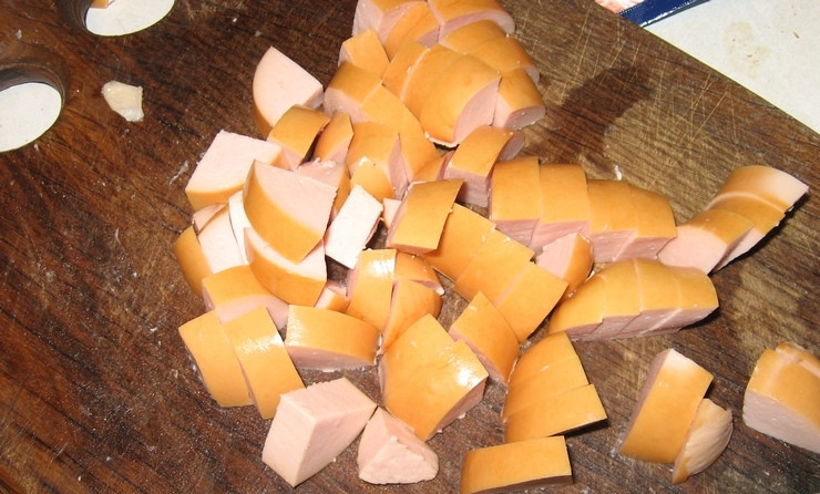 1. Этап. Подлива с сардельками: 1. Сардельки лучше очистить от кожуры и нарезать кружочками. Если сардельки толстые, то их лучше нарезать полукругами. Можно брать сардельки разных сортов.