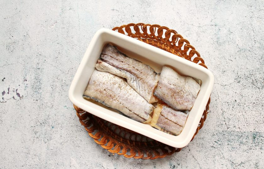 1. Этап. Минтай в сметане с маринованными огурцами: Форму для запекания смажьте растительным маслом, посолите и поперчите.