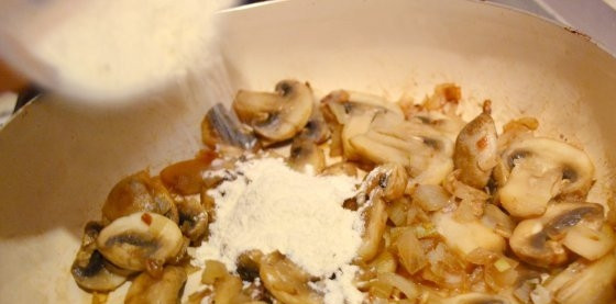 1. Этап. Кальмары, тушенные с шампиньонами: Затем добавьте муку и перемешайте, продолжая готовить на медленном огне. Потом добавьте кальмара. Посолите, поперчите, влейте воду и лимонный сок.