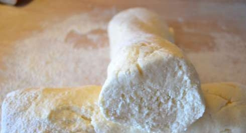 1. Этап. Вареные сырники из творога: Замешайте творожное тесто уже на столе, присыпав его мукой. Сделайте колбаски.