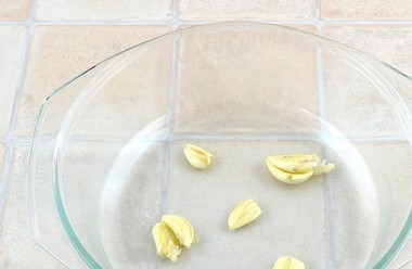 1. Этап. Курица в молоке: Зубчики чеснока почистите. Раздавите их и выложите в жаропрочную форму.