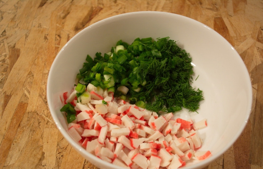 1. Этап. Диетический салат с крабовыми палочками: В миску поместите нарезанные крабовые палочки, зелень.