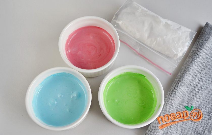 1. Этап. Печенье Елочные игрушки: В конце взбивания влейте лимонный сок, еще пару минут перемешивайте. Разделите белковую массу на несколько частей, в зависимости от количества используемых цветов. Часть обязательно оставьте белой глазури, в остальные добавьте красители и перемешайте.