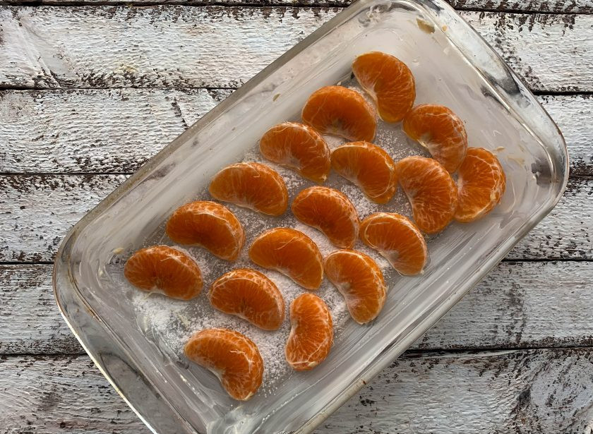 1. Этап. Заливной пирог с мандаринами: Возьмите форму для выпекания, смажьте ее сливочным маслом и выложите мандарины.