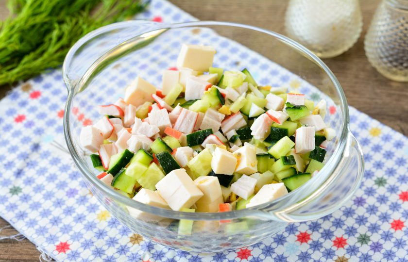 1. Этап. Салат Океан с крабовыми палочками: В миске смешайте нарезанные крабовые палочки, яйца и сыр. Добавьте измельченные свежие огурцы. Посолите салат.